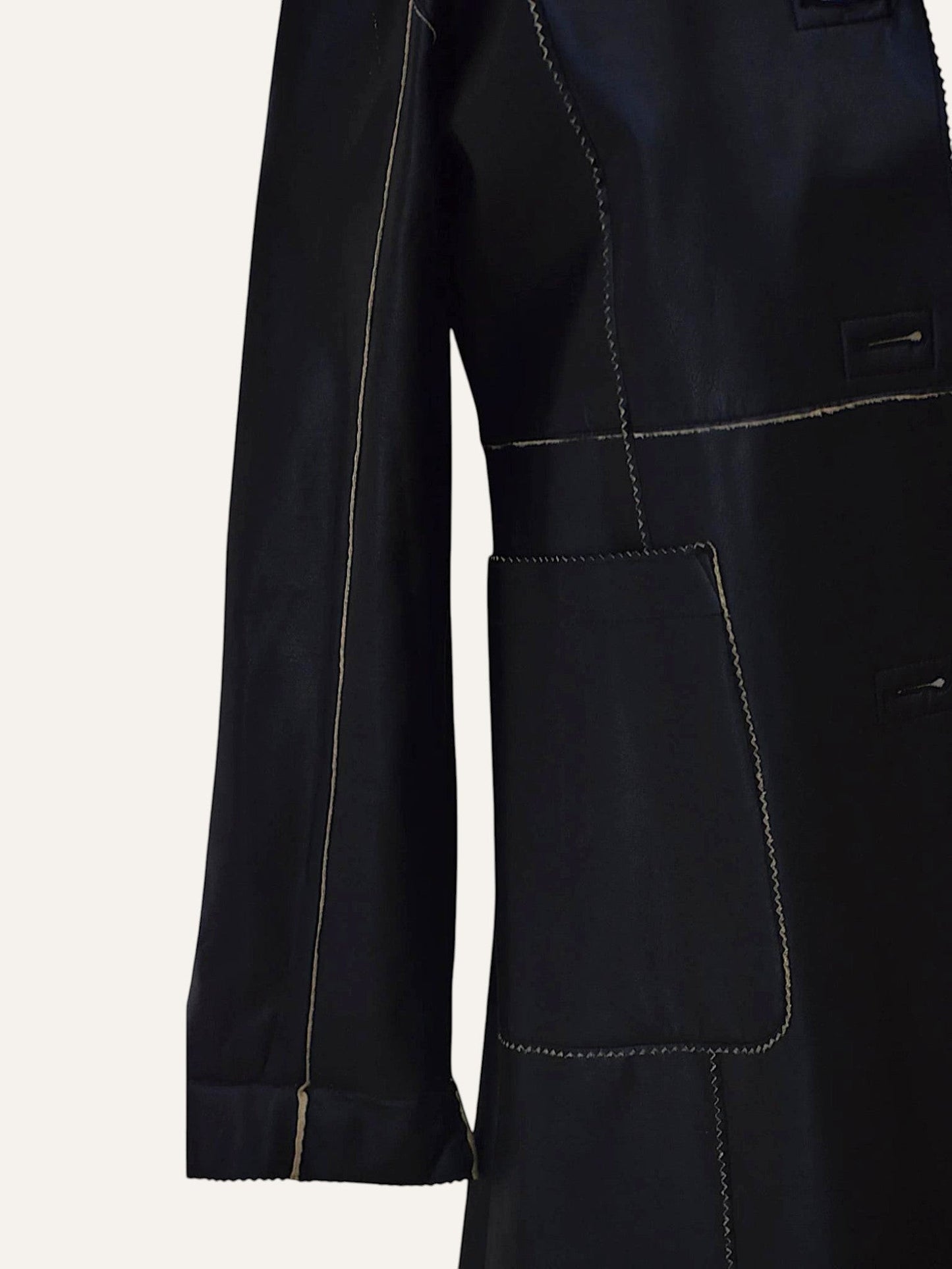 Anemoia Vestiaire black longline faux leather coat with contrasting tan stitching and front pockets.