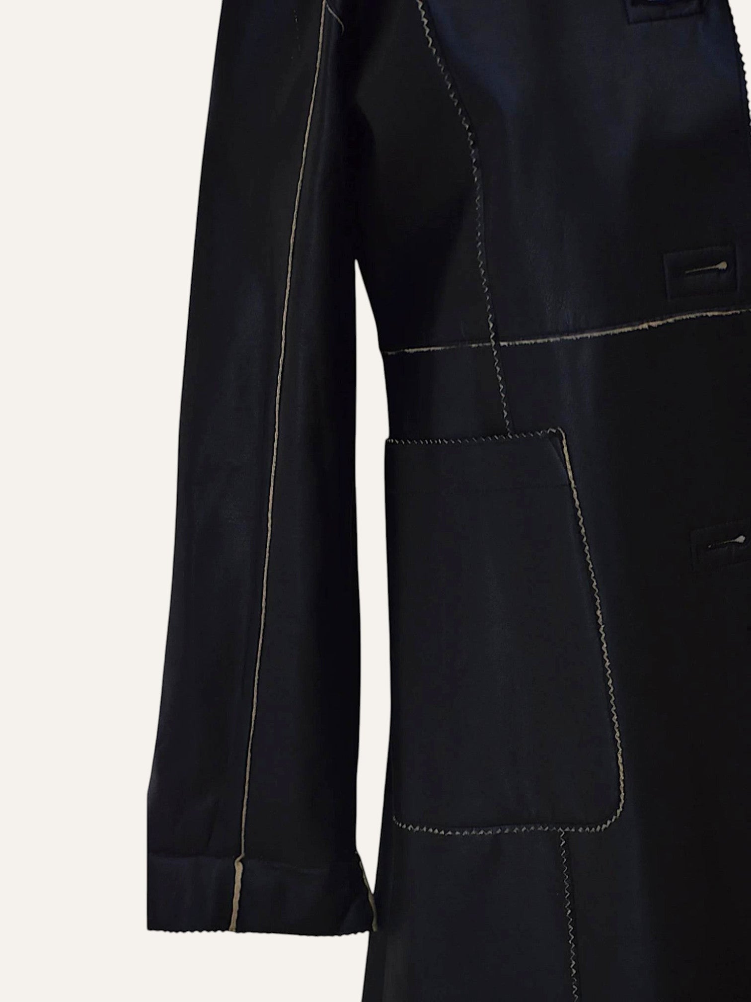 Anemoia Vestiaire black longline faux leather coat with contrasting tan stitching and front pockets.