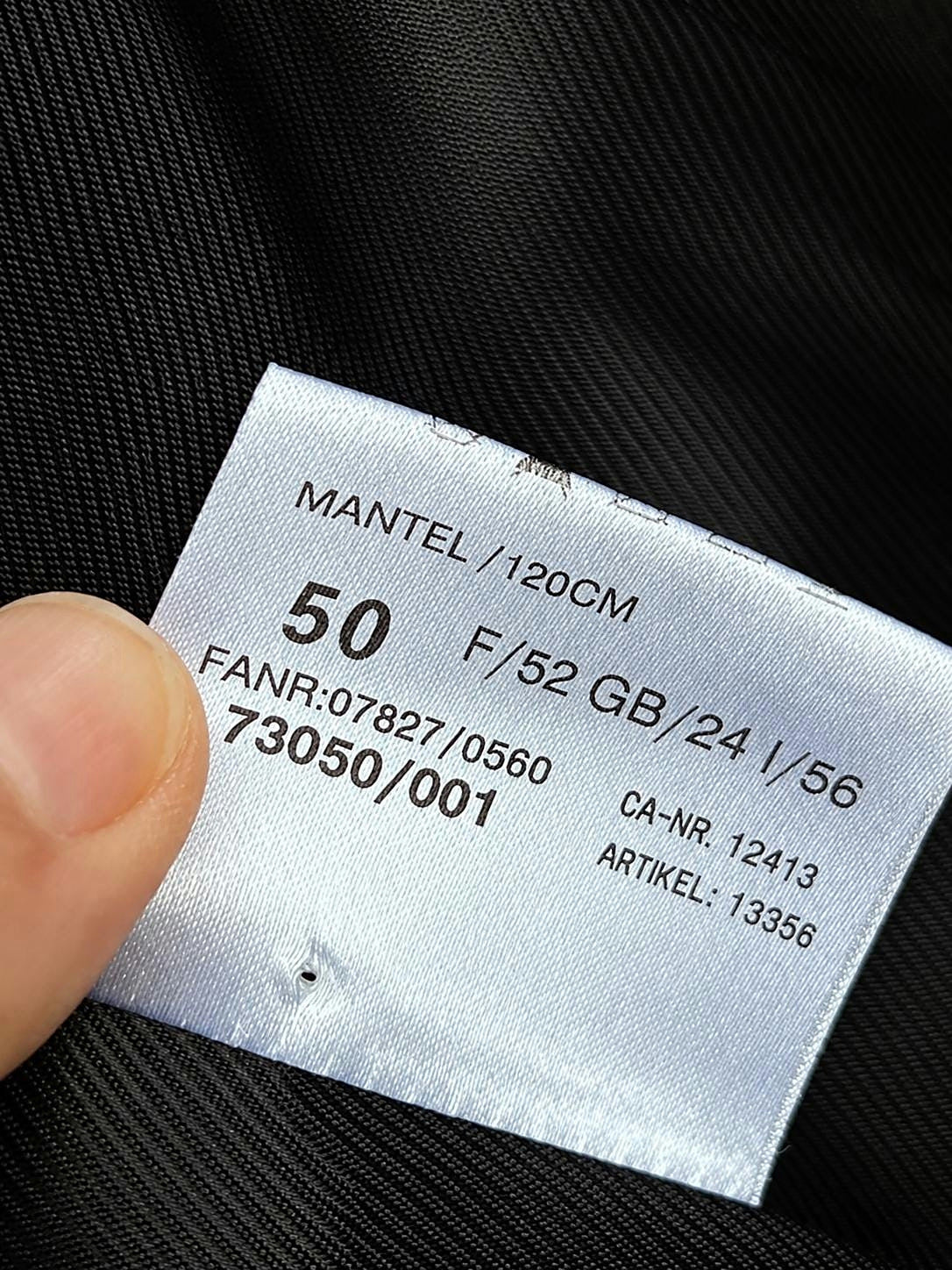 Interior label showing size 50 on the black cashmere overcoat