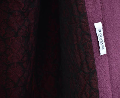 Close-up of a maroon fabric with a brand label on a blurred background