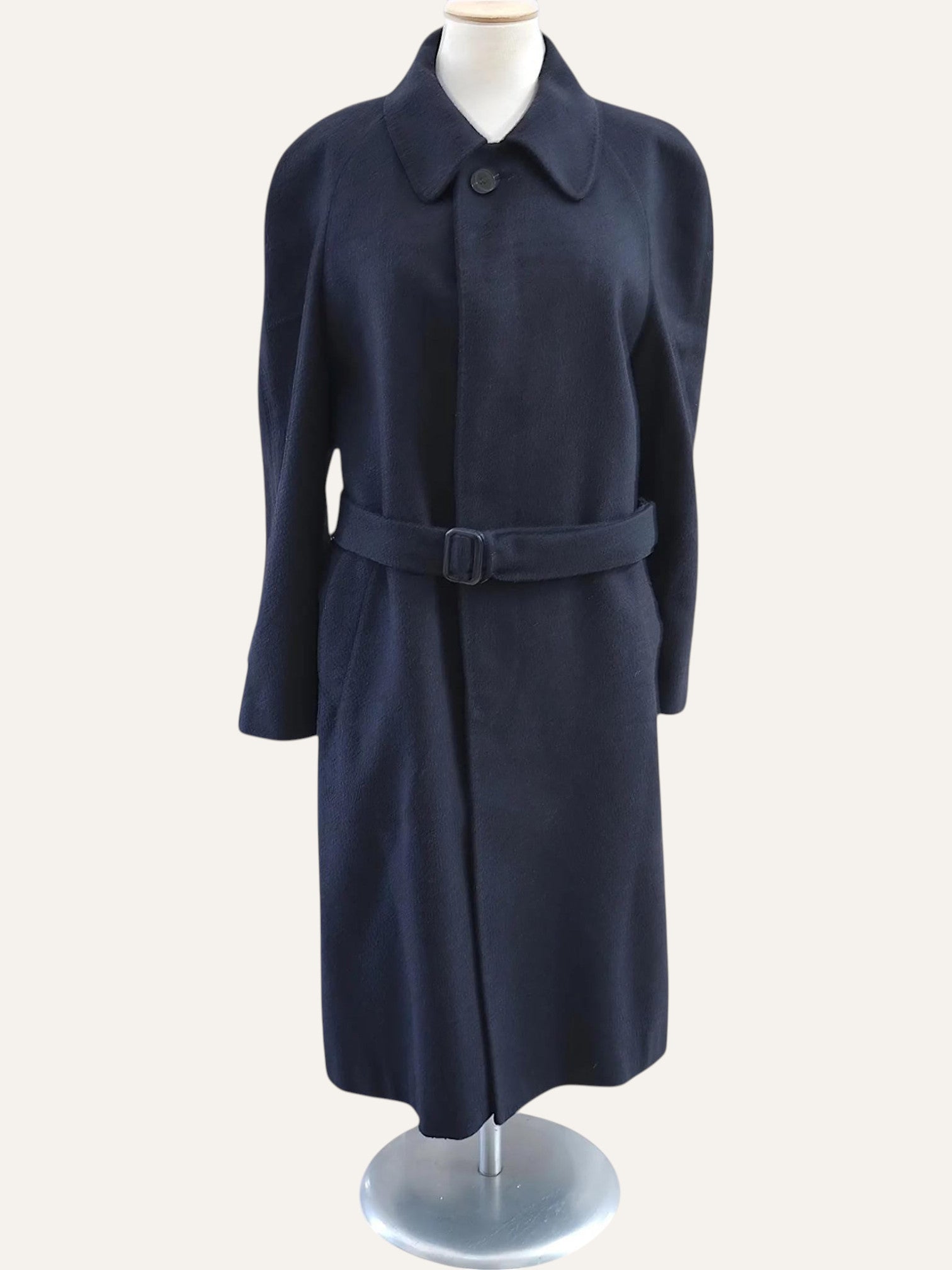 Navy blue coat on a mannequin against a white background