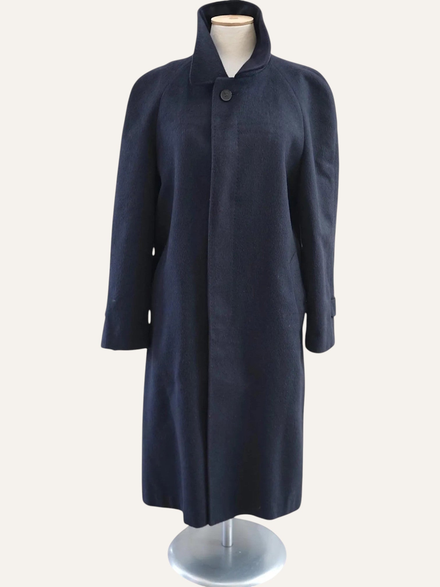 Navy blue coat on a mannequin against a white background