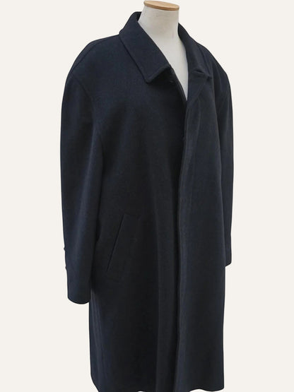 Navy blue coat on a mannequin against a white background