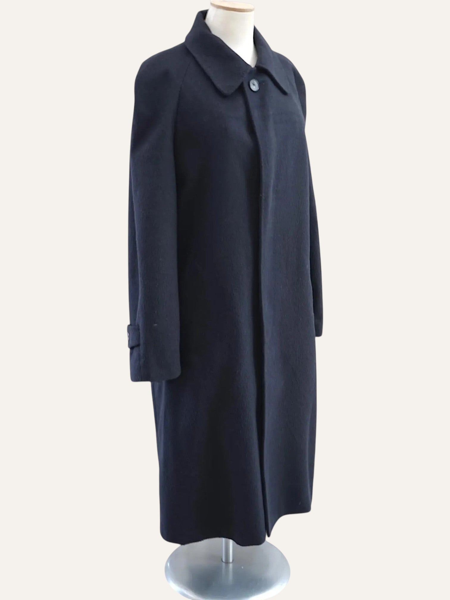 Navy blue coat on a mannequin against a white background