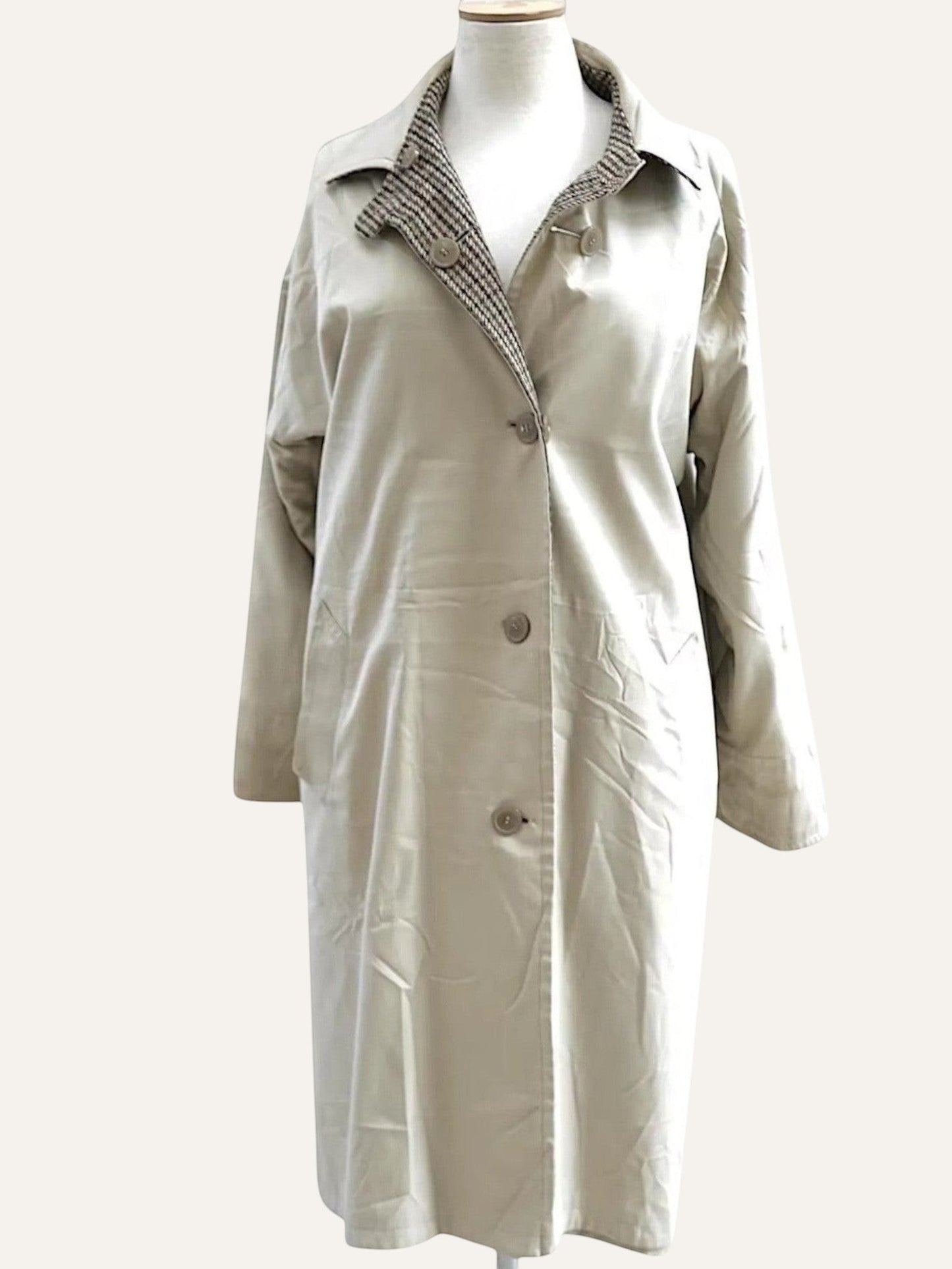 Beige trench coat on a mannequin against a white background