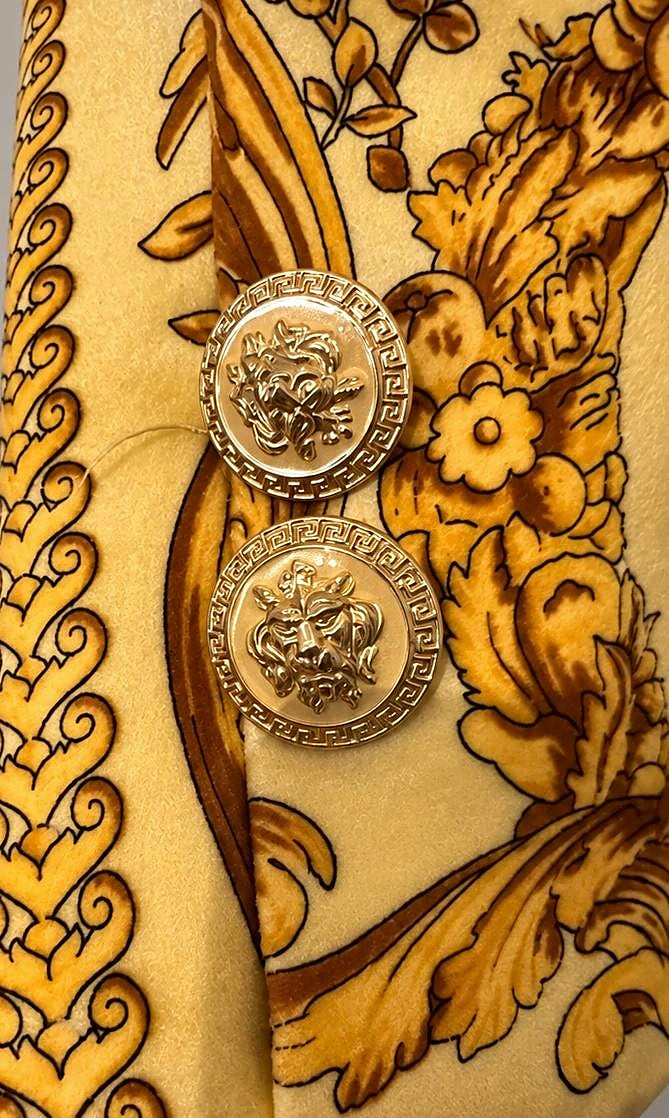 Close view of the embossed gold-tone buttons and acanthus print
