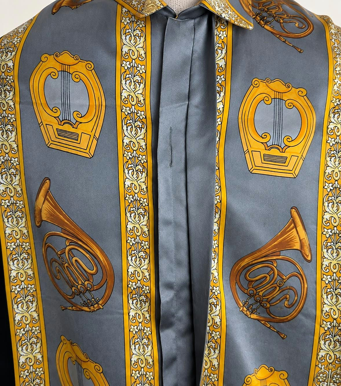 Front panel detail with violin and horn motifs in gold on grey silk